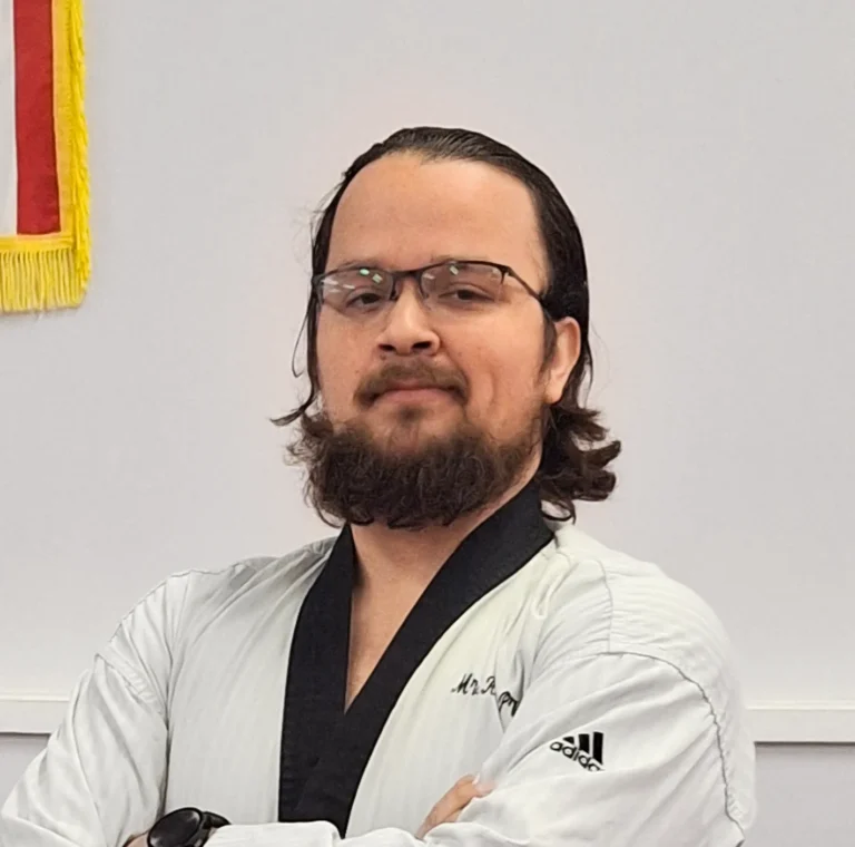 Senior male Taekwondo instructor in white gi and black belt