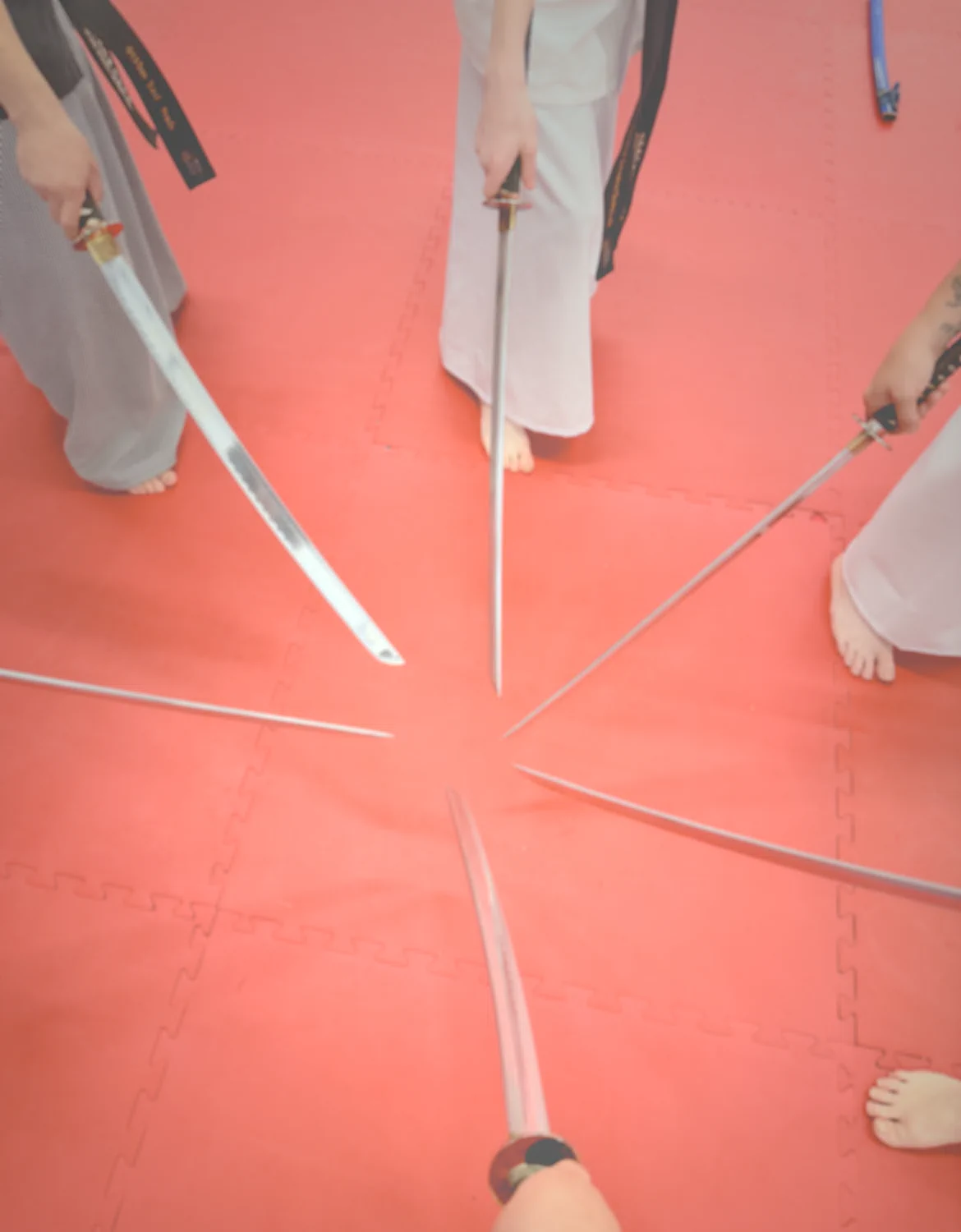 Group of katanas being held in circle.